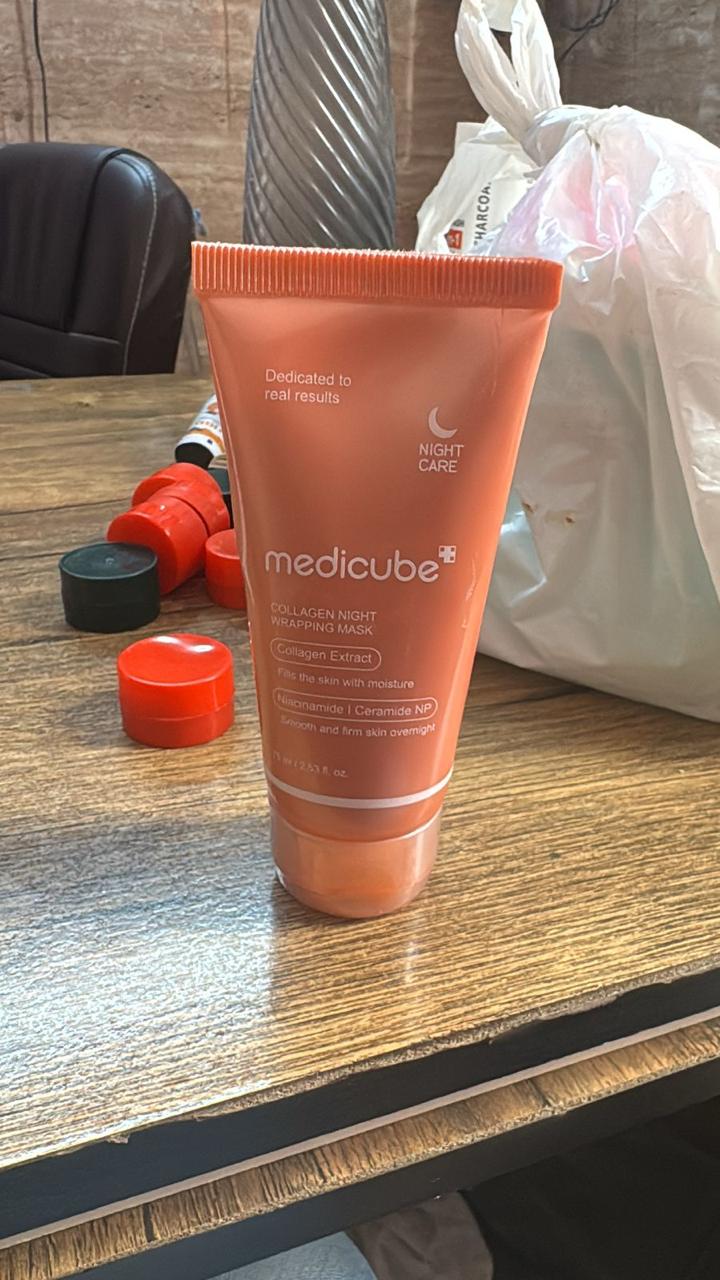 Orange tube of Medicube product on a wooden surface with blurred background